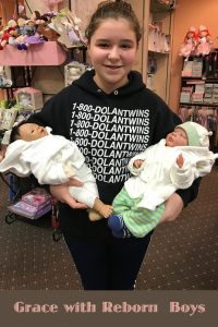 Doll collecting photo of Grace in our shop with two of her reborn dolls.