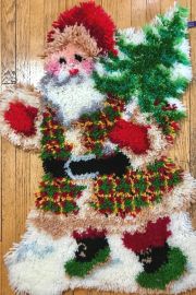 Photo of hand-latched rug featuring Santa with Christmas tree.